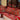a row of red and green couches sitting on top of a wooden table